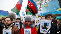 Ukrainian and Crimean Tatar activists hold portraits with the names of victims of the Russian annexation of Crimea during a rally in Kyiv on February 26, 2017. (Sergei Chuzavkov/AP) 