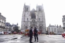 Polisi Perancis memperketat penjagaan saat petugas pemadam kebakaran sedang berupaya memadamkan api di katedral Saint-Pierre-et-Saint-Paul di Nantes, Perancis barat, 18 Juli 2020.