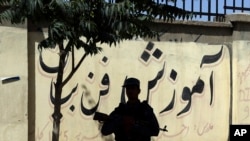 A policeman stands guard near the site of a deadly suicide attack in Kabul, Afghanistan, Monday, June 11, 2018. (AP Photo/Rahmat Gul)