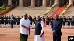 PM India Narendra Modi (tengah), berjabat tangan dengan presiden Sri Lanka, Gotabaya Rajapaksa, disaksikan Presiden India Ram Nath Kovind di New Delhi, 29 November 2019. 