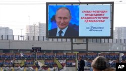 Ljudi prolaze pored velikog ekrana na kojem se prikazuje ruski predsjednik Vladimir Putin i piše: "Sretan rođendan predsjedniku Vladimiru Putinu od braće Srba!", u Beogradu, Srbija, petak, 7. listopada 2022.
