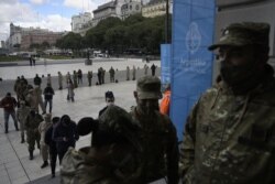 FILE - Members of the Armed Forces queue at the CCK Cultural Centre in Buenos Aires to be inoculated against COVID-19 with the AstraZeneca/Oxford vaccine obtained through the COVAX scheme, on June 15, 2021.