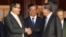 Cambodian Prime Minister Hun Sen, left, shakes hands with opposition party leader Sam Rainsy, right, after a meeting, as Sar Kheng, center, deputy prime minister, looks on at the National Assembly in Phnom Penh, Cambodia, Monday, Sept. 16, 2013.