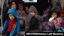 កុមារ​សុំ​សិទ្ធិជ្រកកោន​នៅ​សហរដ្ឋ​អាមេរិក​ ដែល​ធ្វើ​ដំណើរ​មក​ពី​អាមេរិក​កណ្ដាល ជ្រកភ្លៀង​នៅ​ក្នុង​​រថយន្ដ​យាមល្បាត​របស់​ប៉ូលិស​អាមេរិក ខណៈ​ដែល​ពួកគេ​រង់ចាំ​មធ្យោបាយ​ធ្វើ​ដំណើរ​ចូល​សហរដ្ឋ​អាមេរិក នៅ​​ក្រុង Penitas រដ្ឋ Texas ថ្ងៃទី១៤ ខែមីនា​ ឆ្នាំ២០២១។ 