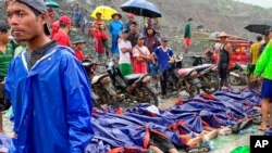 មនុស្សម្នាប្រមូលផ្តុំនៅជិតសាកសពនៃជនរងគ្រោះពីហេតុការណ៍ជំនន់បាក់ដី នៅតំបន់ Hpakant ដែល​ជា​តំបន់​សម្បូរ​ទៅ​ដោយ​ថ្លើម​ថ្ម នៅ​ក្នុង​រដ្ឋ Kachin ប្រទេសមីយ៉ាន់ម៉ា កាលពីថ្ងៃទី០២ ខែកក្កដា ឆ្នាំ២០២០។