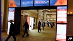 FILE - CinemaCon attendees walk through the lobby during CinemaCon 2018 in Las Vegas, the official convention of the National Association of Theatre Owners, April 26, 2018. 