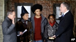 Bill de Blasio (kanan) disumpah sebagai walikota New York City oleh Jaksa Agung Eric Schneiderman (kiri), disaksikan keluarganya. (AP/Seth Wenig)