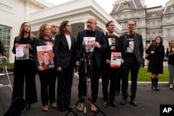 Jonathan Dekel-Chen, father of Sagui Dekel-Chen, center, speaks to reporters after a meeting with U.S. President Joe Biden and the families of Americans who were taken hostage by Hamas during the October 7 terrorist attacks in Israel, Dec. 13, 2023, in Washington.