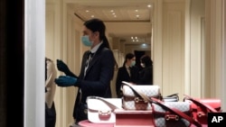 Shop assistants wear masks in a shop in downtown Rome, Jan. 31, 2020. 