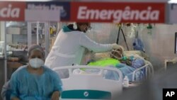 Para petugas kesehatan merawat seorang pasien COVID-19 di unit gawat darurat di rumah sakit lapangan khusus COVID-19 di Ribeirao Pires, Sao Paulo, Brazil, 13 April 2021.