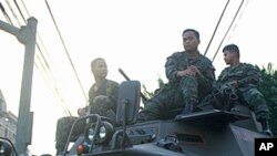 Philippine government soldiers sit on an armored personnel carrier guarding the main gate of the Malacanang presidential palace in Manila February 24, 2006 (file photo).