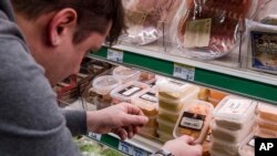 A worker removes expired food in a local supermarket in Brussels on Jan. 16, 2017. The European Court of Auditors chided the European Union's executive branch in a report, "Combating Food Waste," that decries the bloc's lack of effort in reducing the food waste, estimating the EU wastes 88 million tons of food per year.