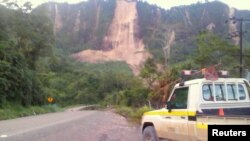 Warga setempat memeriksa lokasi tanah longsor dan jalan yang rusak dekat Kota Tabubil setelah gempa kuat yang mengguncang Dataran Tinggi Selatan di Papua Nugini, 26 Februari 2018. F(Foto: Jerome Kay via Reuters)