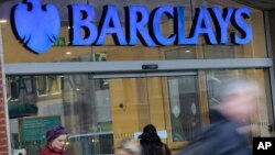 Customers wait outside a retail branch of Barclays Bank for the bank to open in London.