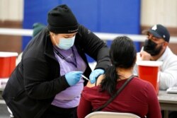 A Pfizer COVID-19 vaccine is administered at the Banning Recreation Center in Wilmington, Calif., April 13, 2021. The site switched from its original plan to use the Johnson & Johnson vaccine to the Pfizer vaccine.