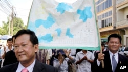 FILE - Marchers with opposition Sam Rainsy Party hold a Cambodia map supporting territorial claims against Vietnam on a street in Phnom Penh.