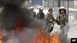 Polisi Afghanistan siaga sementara para demonstran yang marah membakar ban-ban dekat pangkalan AS di Kabul, Afghanistan (17/9). 