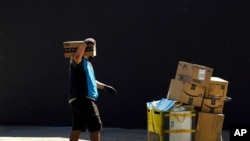 FILE - In this photo taken Feb. 5, 2019, a woman works at a distribution Amazon fulfillment center in Staten Island, one of the five boroughs of New York City.