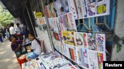 A girl selling weekly journals waits for customers in Rangoon, Burma, April 2, 2012. 