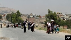 Sirijci nose potrepštine po povratku iz predgrađa Damaska, Muadamijat, tada pod kontrolom pobunjenika, 13. jula 2014.