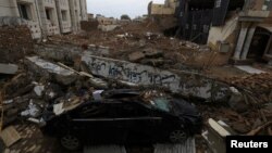Sebuah mobil terlihat di bawah puing-puing masjid yang diserang oleh seorang pelaku bom bunuh diri pada Januari lalu, di kawasan Garis Polisi di Peshawar, Pakistan, 9 Februari 2023. (Foto: Reuters)