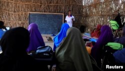 រូបឯកសារ៖ លោក Abdiweli Mohammed Hersi បង្រៀន​សិស្ស​ក្មេងៗ​នៅ​សាលា​រៀន​មួយ​ជិត​ជំរំ​ជន​ភៀស​ខ្លួន​ដែល​បាត់​បង់​ទីជម្រក​ដោយ​សារ​គ្រោះ​រាំង​ស្ងួត​នៅ​ទីក្រុង Dollow ប្រទេស​សូម៉ាលី កាល​ពីឆ្នាំ ២០១៧។