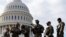 National Guard troops receive guns and ammunition outside the U.S. Capitol 