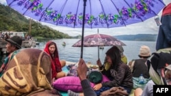 Warga berkumpul di pinggir Danau Toba (20/6) menunggu kabar anggota keluarga sementara tim penyelamat mencari korban penumpang Kapal Motor Sinar Bangun yang tenggelam di Danau Toba.