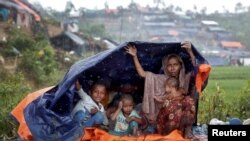 Pengungsi Rohingya berlindung dari hujan di kamp di Cox's Bazar, Bangladesh, 17 September 2017.