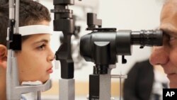 Dr. Albert Maguire checks the eyes of Misa Kaabali, 8, at the Children’s Hospital of Philadelphia, Oct. 4, 2017. Misa was 4 years old when he received his gene therapy treatment.