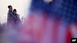 Two people visit a makeshift memorial for victims of a mass shooting at a shopping complex in El Paso, Texas, Aug. 5, 2019.