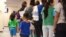 FILE - A photo provided by U.S. Immigration and Customs Enforcement shows mothers and their children standing in line at South Texas Family Residential Center in Dilley, Texas, Aug. 9, 2018.