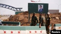 Syrian soldiers stand at the Naseeb border crossing with Jordan in Deraa, Syria, July 7, 2018. 