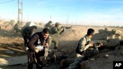 Iraqi security forces take combat positions on the front line with Islamic State group militants in Ramadi, capital of Anbar province, 70 miles (115 kilometers) west of Baghdad, Dec. 10, 2015.