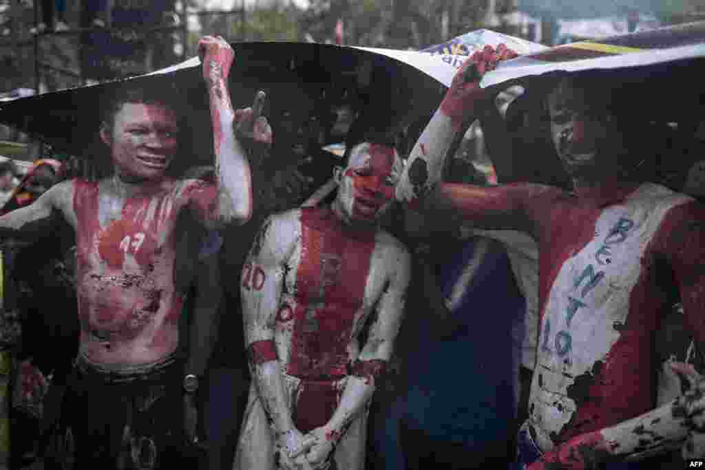 Wafuasi wa rais Felix Tshisekedi wakijifunika kiutokana na mvua wakimsubiri kuwasili mjini Goma Disemba 10, 2023.