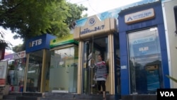  រូបឯកសារ៖ អតិថិជន​ម្នាក់​ដើរ​ចេញ​ពី​​ទូរ​ដាក់​ម៉ាស៊ីន​ដក​ប្រាក់​ស្វ័យ​ប្រវត្តិ ដែល​មាន​ទីតាំង​តាម​បណ្តោយ​ផ្លូវ​នរោត្តម ខាង​ត្បូង​វិមាន​ឯក​រាជ្យ កាល​ពី​ថ្ងៃទី ៨ សីហា ឆ្នាំ២០១៥។ (អ៊ុច នីដា/VOA)