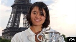 Li Na berpose di depan menara Eiffel setelah menjuarai kejuaraan grand slam Perancis terbuka dengan menundukkan petenis Italia Francesca Schiavone (6/6). Li Na meninggalkan sistim pembinaan olahraga Tiongkok sejak tahun 2008.