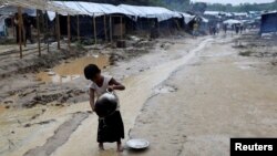 A Rohingya refugee child washes utensils in the Balukhali refugee camp in Cox's Bazar, Bangladesh, Oct. 6, 2017. 