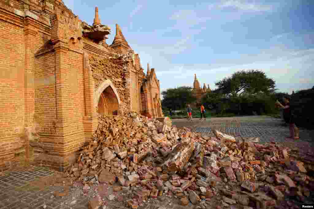 People walk past a damaged pagoda after an earthquake in Bagan, Aug. 25, 2016.