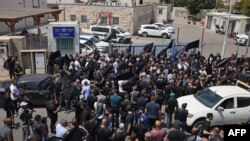 Para pelayat mengibarkan bendera hitam dan mengenakan kaus hitam bergambar Abdelrahman Kashua, dalam aksi protes di depan kantor polisi kota Tira, Israel hari Rabu (23/8). 