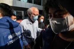 John Clancey, a US solicitor with law firm Ho Tse Wai and Partners that is known for taking on human rights cases is led away by police after he was arrested in Hong Kong on Jan.y 6, 2021.