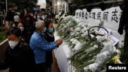People queue up to pay tribute to former Chinese President Jiang Zemin, after he died aged 96, outside China's Liaison Office, in Hong Kong, Dec. 1, 2022.