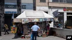 A man checks newspapers' front pages at a kiosk in Athens, June 5, 2020. 