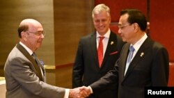 U.S. Secretary of Commerce Wilbur Ross shakes hands with China's Premier Li Keqiang, as U.S. National Security advisor Robert O'Brien watches, as they attend a meeting during the 35th ASEAN Summit in Bangkok, Thailand.
