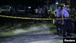Police officers stand behind a police line after a man was killed during a police anti-drug operation in Caloocan city, Metro Manila, Philippines, Aug. 17, 2017.
