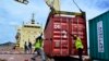 Des ouvriers déplacent un conteneur de riz dans le port de Cotonou, au Bénin, le 13 octobre 2014. 