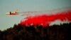 Pesawat ringan menebarkan bahan kimia untuk memadamkan kebakaran lahan Kincade Fire dekat Healdsburg, California, Selasa, 29 Oktober 2019. 