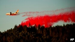 Pesawat ringan menebarkan bahan kimia untuk memadamkan kebakaran lahan Kincade Fire dekat Healdsburg, California, Selasa, 29 Oktober 2019. 