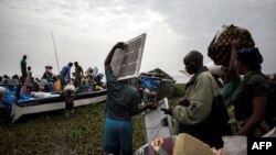 Des personnes embarquent dans des pirogues sur le lac Albert pour fuir les violences en Itrui vers l'Ouganda à Tchomia, le 5 mars 2018.