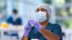 Seorang tenaga kesehatan sedang menyiapkan vaksin Pfizer di Pusat Vaksinasi COVID-19 yang baru dibuka di Sydney, Australia, Senin, 10 Mei 2021. (Foto: James Gourley via AP)